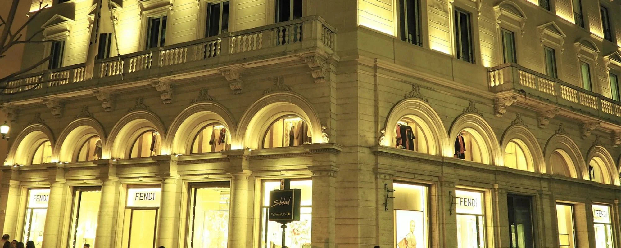 Fendi contemporary architecture store front building with warm yellow light selling new and used vintage Fendi bags like classic zucca baguette mama - Forgotten Luxuries