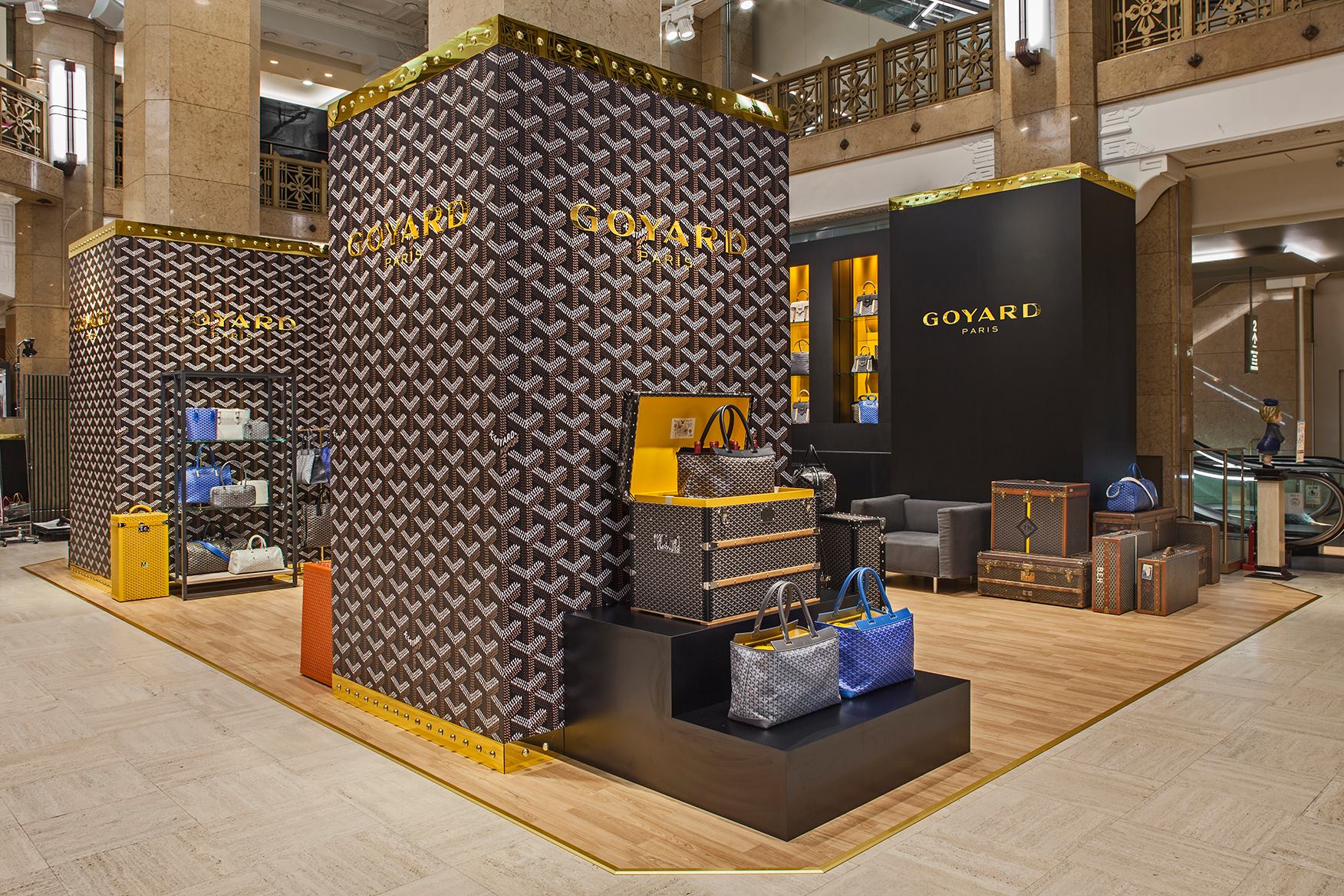 Iconic Goyard logo of Goyardine canvas interlocking Ys and dots in a goyard store displaying new and used vintage Anjou GM bags and saigon tote bags - Forgotten Luxuries