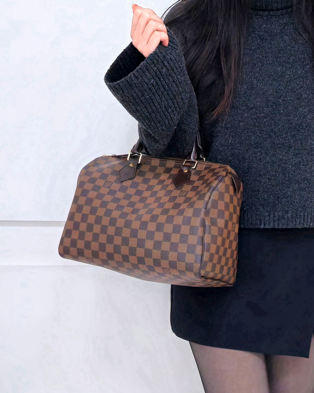 Louis Vuitton Speedy 30 Damier Ebene holding in knit sweater and skirt model - Forgotten Luxuries