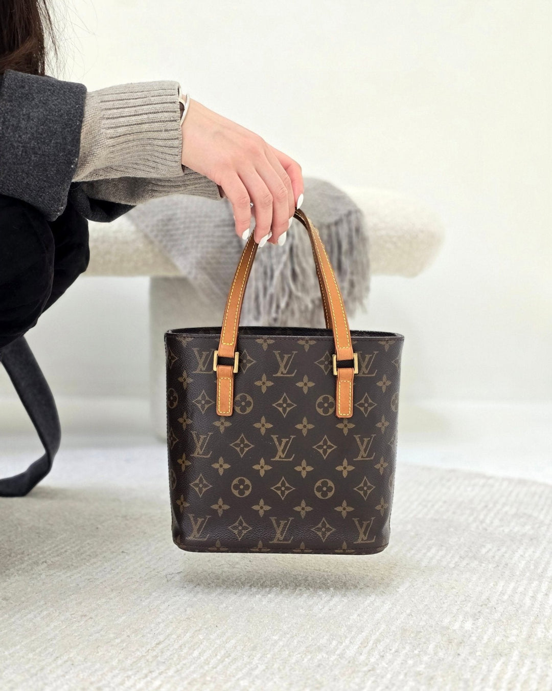 Female in knit sweater holding a Louis Vuitton Vavin PM Monogram hovering over the floor Forgotten Luxuries