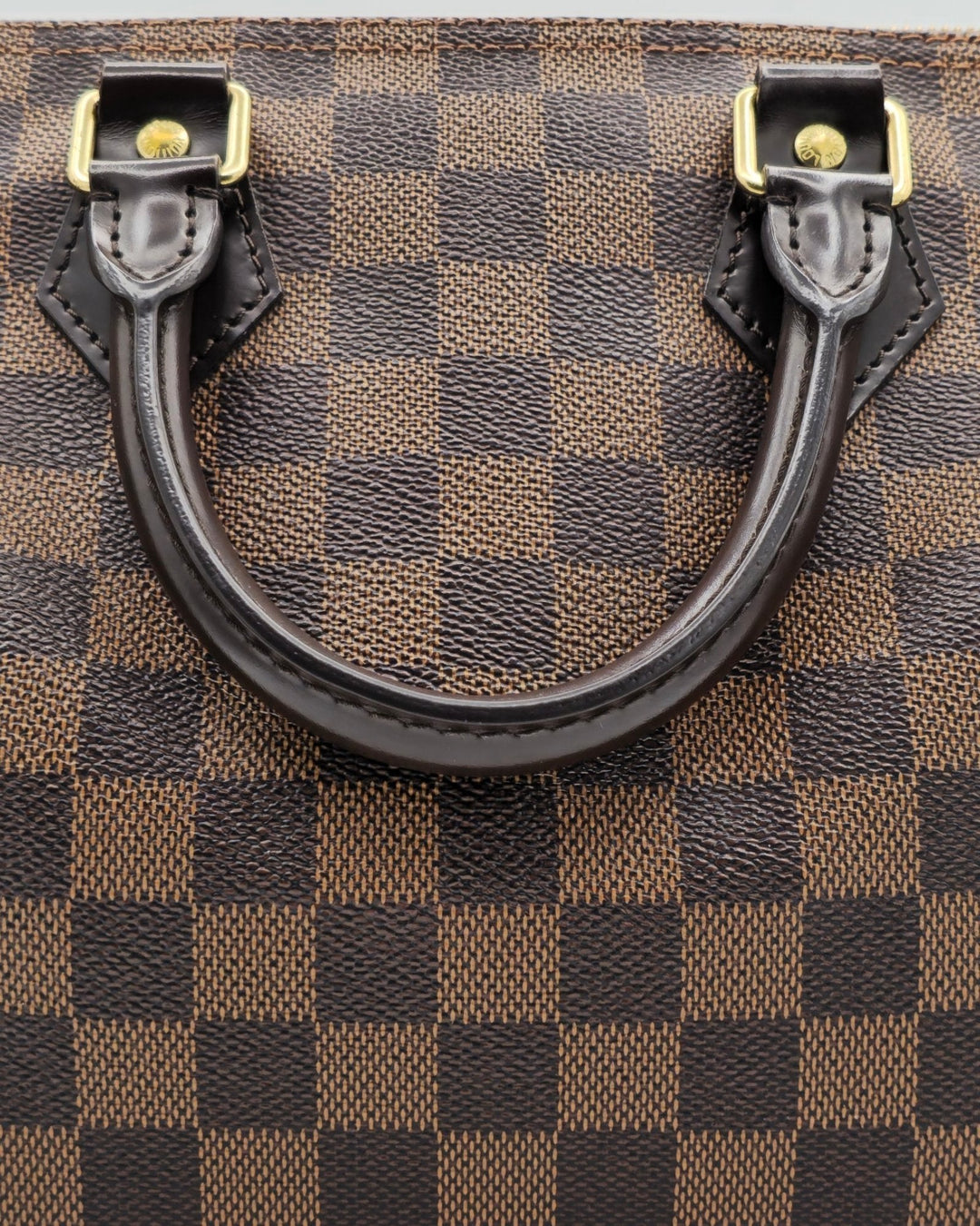 Louis Vuitton Damier Ebene Speedy Bandouliere 25 Louis VuittonDamier Ebene Speedy Bandouliere 25Louis Vuitton LV Damier Ebene Speedy Bandouliere 25 bag brown canvas leather with gold hardware side profileForgotten Luxuries Forgotten Luxuries