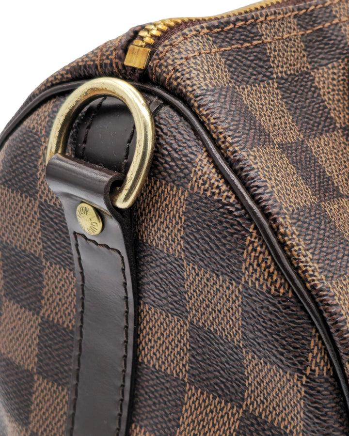 Louis Vuitton Damier Ebene Speedy Bandouliere 25 Louis VuittonDamier Ebene Speedy Bandouliere 25Louis Vuitton LV Damier Ebene Speedy Bandouliere 25 bag brown canvas leather with gold hardware side profileForgotten Luxuries Forgotten Luxuries